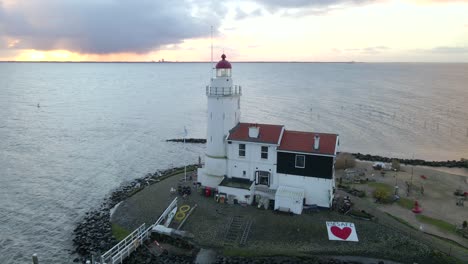 Circling-around-famous-Lighthouse-in-Holland-at-dawn,-Horse-of-Marken