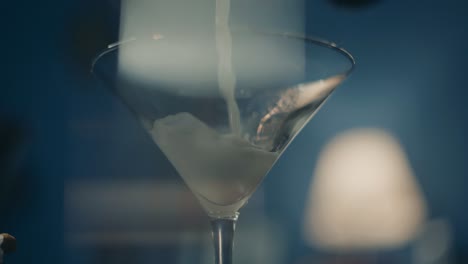 Pouring-cocktail-drink-in-glass,-close-up-slow-motion,-cinematic-depth-of-focus