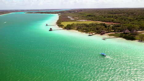 Beautiful-drone-shot-of-turquoise-waters-at-Bacalar-Mexico-with-a-boat-in-the-water