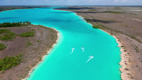 Chasing-drone-shot-of-jet-skiers-in-the-clear-blue-waters-at-Bacalar-Mexico