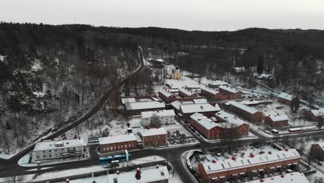 Aerial-flyover-rural-Swedish-village-of-Jonsered-during-snowy-winter-day