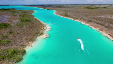 Cinematic-chasing-drone-shot-of-jet-skiers-and-clear-blue-waters-at-Bacalar-Mexico