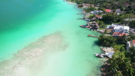 Revealing-drone-shot-of-turquoise-waters-and-homes-in-Bacalar-Mexico