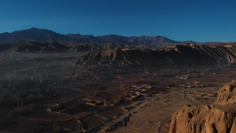 Hombre-Parado-En-Lo-Alto-De-Un-Acantilado-Mirando-La-Ciudad-De-Bamyan-Por-La-Mañana-En-Afganistán