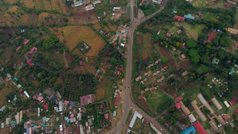 Aerial-view-above-traffic-on-a-road,-in-a-rural-village-in-Kenya,--overhead,-drone-shot