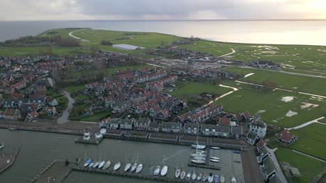 Golden-hour-sunlight-shines-over-historic-town-Marken-in-Holland,-aerial