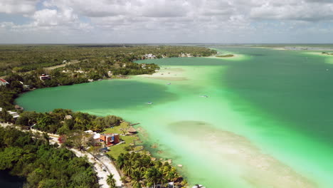 Rotating-shot-of-turquoise-color-water-and-homes-at-Bacalar-Mexico
