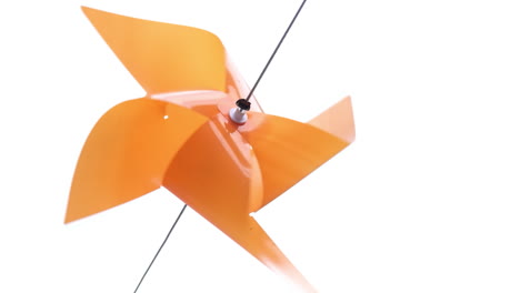 Orange-color-plastic-pinwheel-rotates-with-blowing-wind