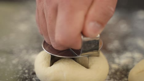Baker-Making-Kaiser-Roll-Buns-from-Dough,-Close-Up-on-Hands-in-Slow-Motion