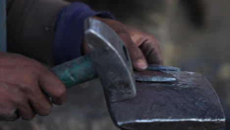 Blacksmith-Hammers-A-Horseshoe-To-Straighten-It-In-A-Workshop-At-Bamyan,-Afghanistan---close-up