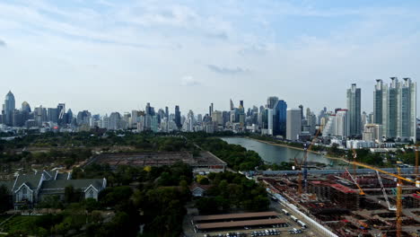 Timelapse-of-a-very-clear-day-of-a-modern-city-skyline-of-Bangkok,-Thailand,-including-auto-and-water-traffic,-and-construction-cranes