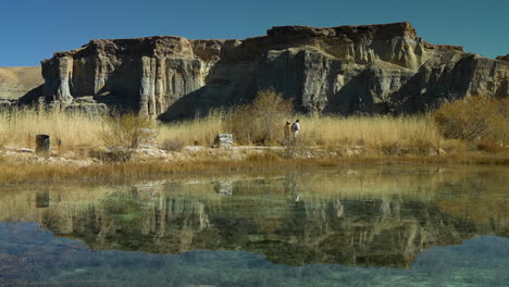 Reflection-Of-People-Walking-Near-Lake-In-Band-e-Amir-National-Park-In-Bamyan,-Province-Of-Central-Afghanistan