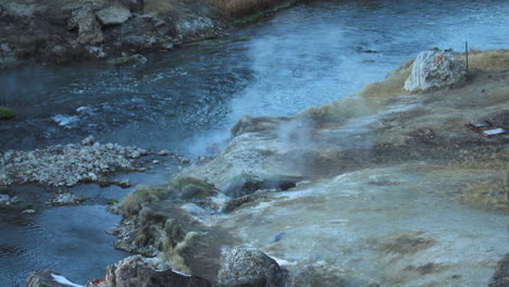Hot-Steam-Along-Water-Stream-at-Hot-Creek-Geological-Site,-Inyo-National-Forest,-Slow-Motion,-High-Angle