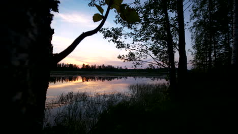 Stille-In-Der-Natur,-Zeitraffer-Des-Sommernachthimmels,-Der-Sich-In-Einem-Ruhigen-See-In-Skandinavien-Widerspiegelt