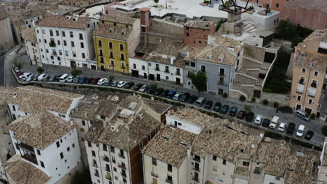 Cars-Parked-Outside-Cliffside-Apartment-Buildings-Near-Mangana-Tower-In-Cuenca,-Spain