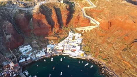 Aerial-video-of-famous-whitewashed-and-colourful-picturesque-village-of-Oia-built-on-a-cliff-during-sunset,-Santorini-island,-Cyclades,-Greece
