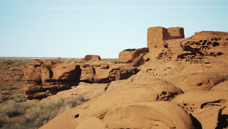 Trucking-shot-with-sandstone-rock-formations-and-ruined-building-in-background