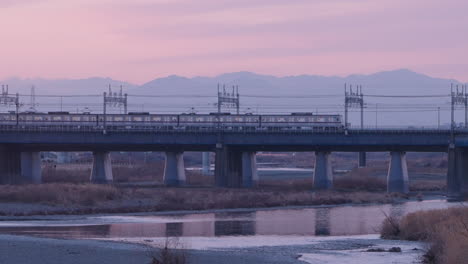 Trenes-De-La-Estación-Futako-tamagawa-Que-Cruzan-El-Puente-Del-Río-Tama-Durante-La-Puesta-De-Sol-En-Tokio,-Japón