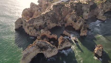Limestone-cliffs-and-rocks-bathed-with-soft-sunlight,-Atlantic-ocean,-Lagos,-Algarve