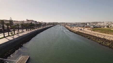 Boats-moored-at-pier-along-Bensafrim-river,-Lagos,-Algarve