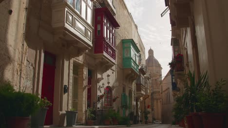 Slow-pan-of-a-historic-street-with-coloured-balconies-in-Birgu,-one-of-the-Three-Cities-of-Malta