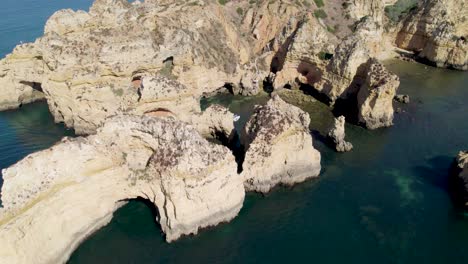 Fly-over-Kayaks-and-boats-in-Algarve-grottos-yellow-golden-cliffs