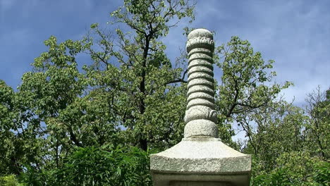 Top-of-a-stone-pagoda-against-a-background-of-trees-and-sky