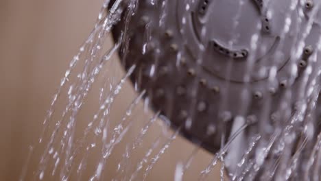Water-flowing-from-shower-head-in-the-bathroom,-close-up-shot