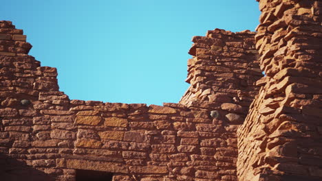 Panning-shot-of-old-ruins-of-Wukoki-Pueblo-on-sunny-day