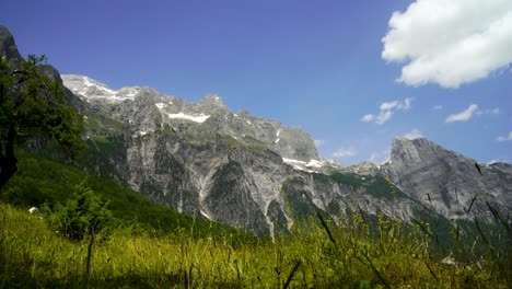 Grüne-Wiese-Am-Hang-Der-Alpenberge-An-Einem-Windigen,-Bewölkten-Tag-In-Theth,-Albanien