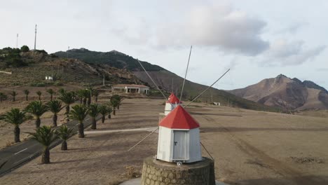 Flying-through-blades-of-old-wooden-windmills-on-top-of-hill-in-Porto-Santo