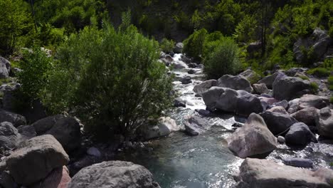 Creek-water-streaming-on-polished-stones-falling-from-high-mountains-in-Albanian-Alps