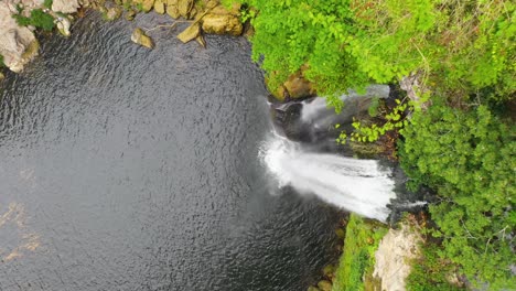 Aerial-top-down-view-of-tropical-waterfall-cascading-over-precipice