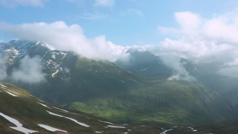 Luftaufnahme-Eines-Grünen-Tals-Mit-Schneeresten-In-Den-Alpen-Während-Des-Sommerers