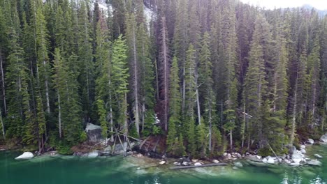 Panning-Left-Drone-Shot-of-the-Rocky-Alpine-Coast-of-Colchuck-Lake-and-Forest,-near-The-Enchantments-in-Washington's-Cascade-Mountain-Range