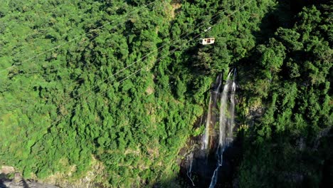 Aerial-view-showing-gigantic-waterfall-surrounded-by-green-forest-trees-and-mountains-in-nature-of-Taiwan