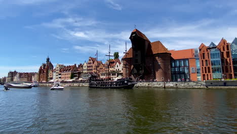Danziger-Altstadt---Hölzernes-Touristisches-Schiff,-Das-Als-Piratenboot-Stilisiert-Ist,-Und-Moderne-Yachten-Auf-Der-Mottlau-In-Der-Nähe-Des-Krans-Im-Historischen-Teil-Von-Danzig-Tagsüber