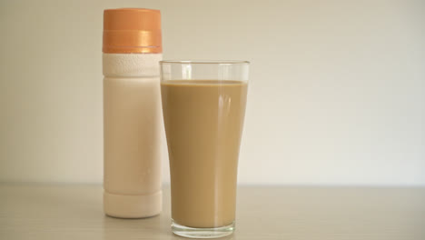 Kaffee-Latte-Glas-Mit-Trinkfertigen-Kaffeeflaschen-Auf-Dem-Tisch