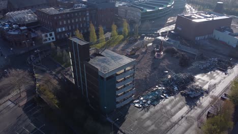 Demolished-multi-storey-car-park-concrete-construction-debris-in-town-regeneration-aerial-rising-view-demolition-site