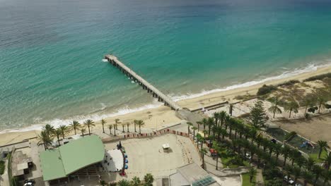 Aerial-of-Fontinha-beach-in-Porto-Santo-with-concrete-pier-and-blue-water