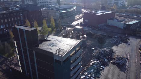 Demolished-multi-storey-car-park-concrete-construction-debris-in-town-regeneration-aerial-view-demolition-close-orbit-left