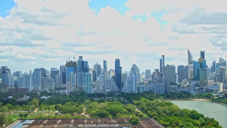 Clouds-timelapse-over-Bangkok-cityscape-daytime-from-a-high-point,-numerous-skyscrapers-of-downtown-business-district,-Benjakitti-Park,-CTI-Tower,-Queen-Sirikit-National-Convention-Centre-construction