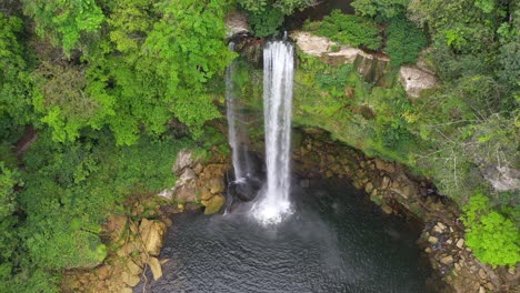 Aerial:-tall-Mexican-Misol-Há-waterfall-cascading-over-canyon,-arc-shot