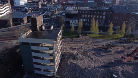 Demolished-multi-storey-car-park-concrete-construction-debris-in-town-regeneration-aerial-slow-left-orbit-view-demolition