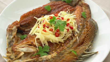 Gebratener-Wolfsbarschfisch-Mit-Fischsauce-Und-Würzigem-Salat-Auf-Dem-Teller