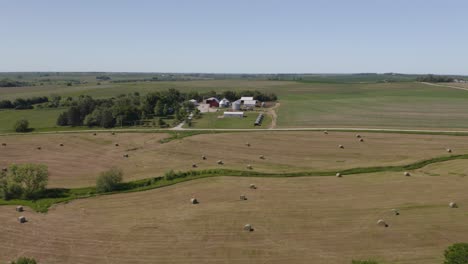 Aerial-View-of-Hay-Bales-with-Farm-House-in-Background