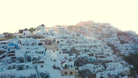 Amazing-video-of-famous-white-and-colourful-picturesque-village-of-Oia-built-on-a-cliff-at-sunset,-Santorini-island,-Cyclades,-Greece