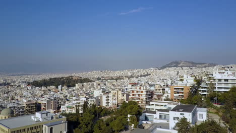 Toma-Aérea-Moviéndose-Hacia-Atrás-Pasando-Por-Edificios-En-Atenas-Grecia,-4k