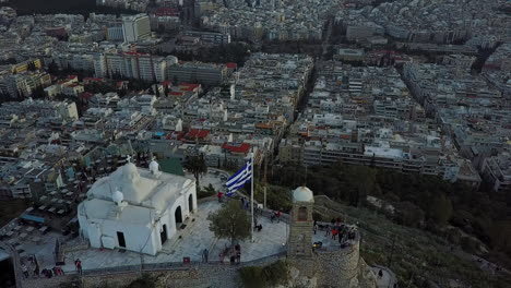 Aerial-drone-shot-coming-over-top-of-Mount-Lycabettus-in-Athens-Greece,-4K