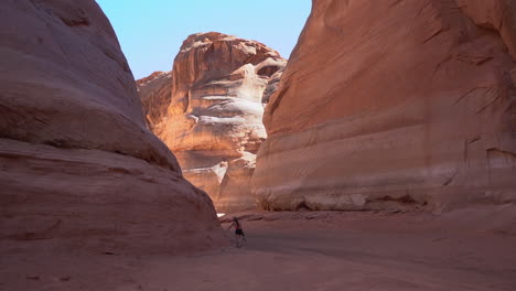 Lonely-Female-Figure-Walking-Between-Sandstone-Cliffs-in-Antelope-Slot-Canyon